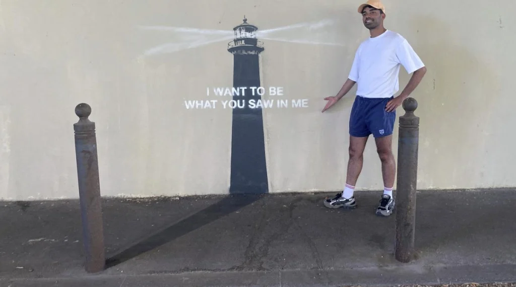 A Man posing infront of Banksy's mural. Courtesy - The Hindu