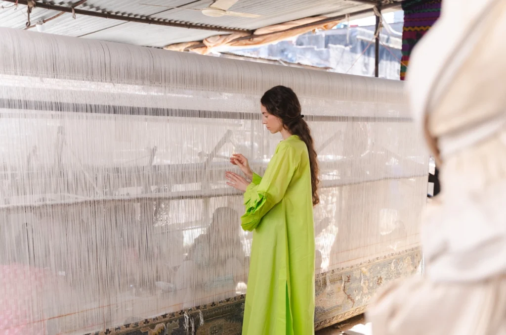 Elvira Voynarovska exploring the hand-weaving of carpets during her residency at Jaipur Rugs (Jaipur) Courtesy - Samuel Adams